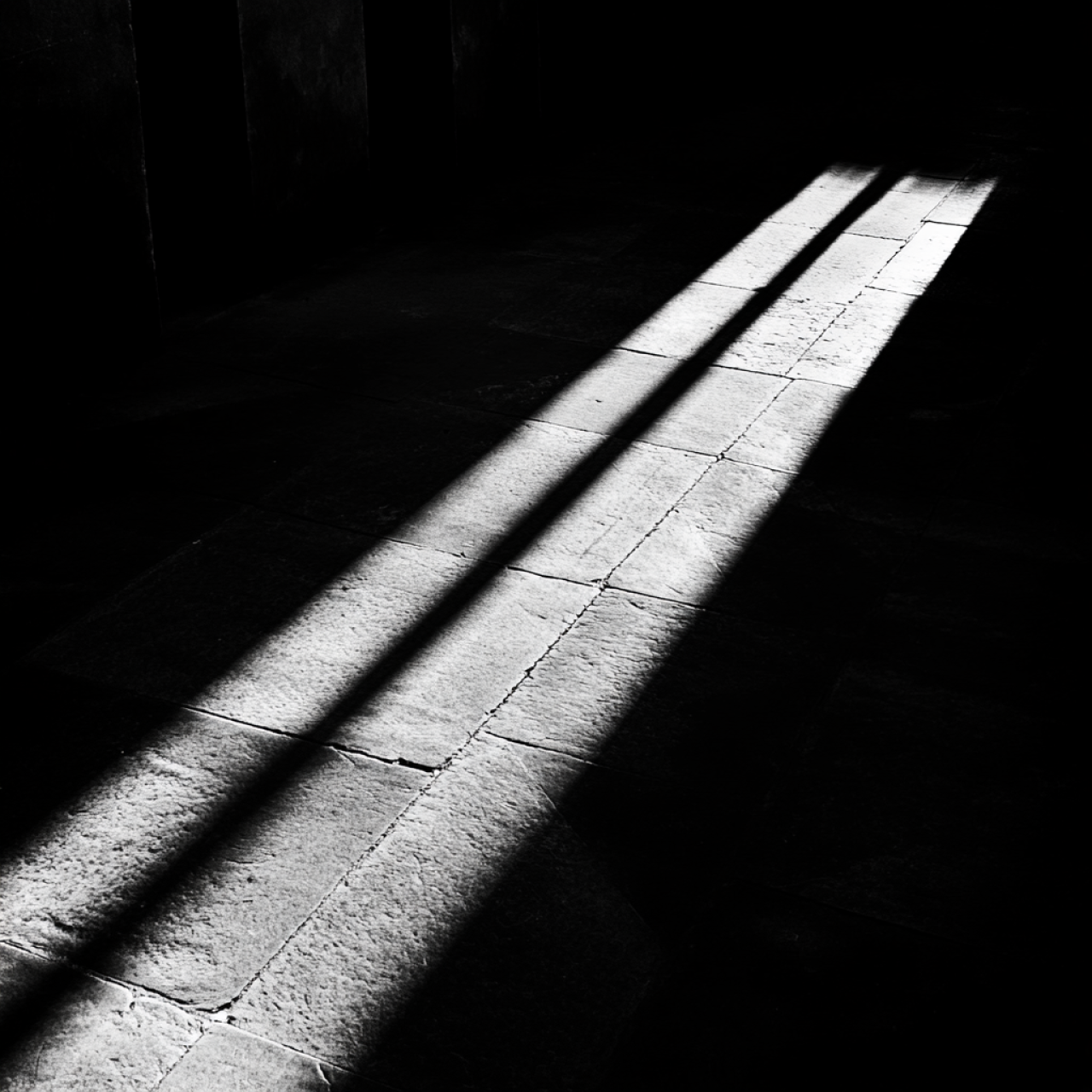 Eine dunkler Weg. In der Mitte ein Lichtstrahl, rechts und links alles dunkel.